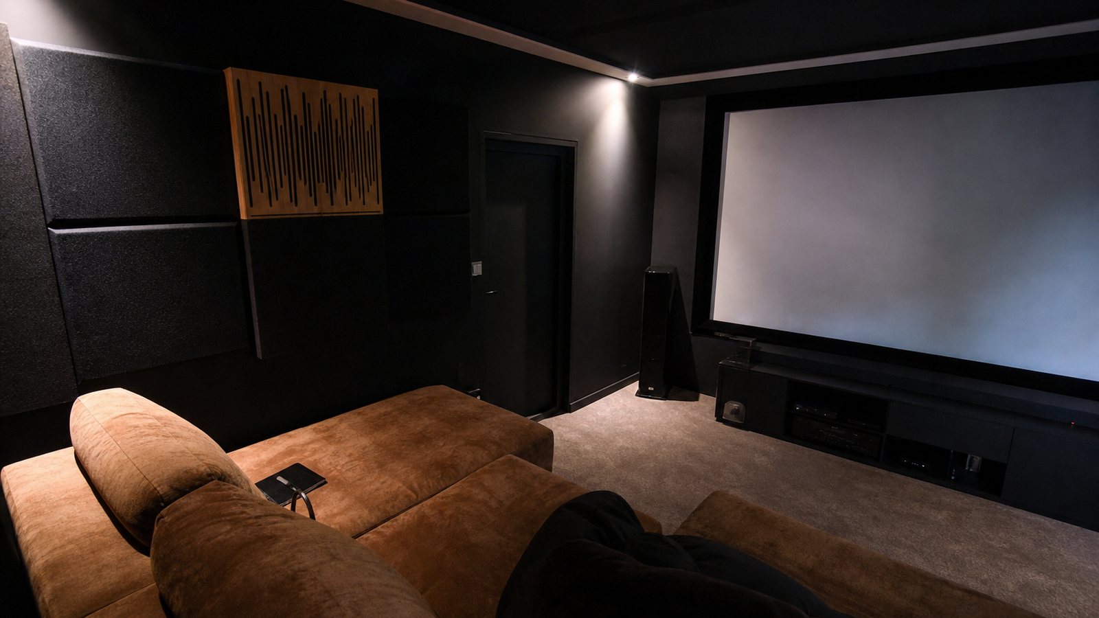 Panneaux acoustiques et enceintes intégrés aux parois d'une salle de home cinéma privée
